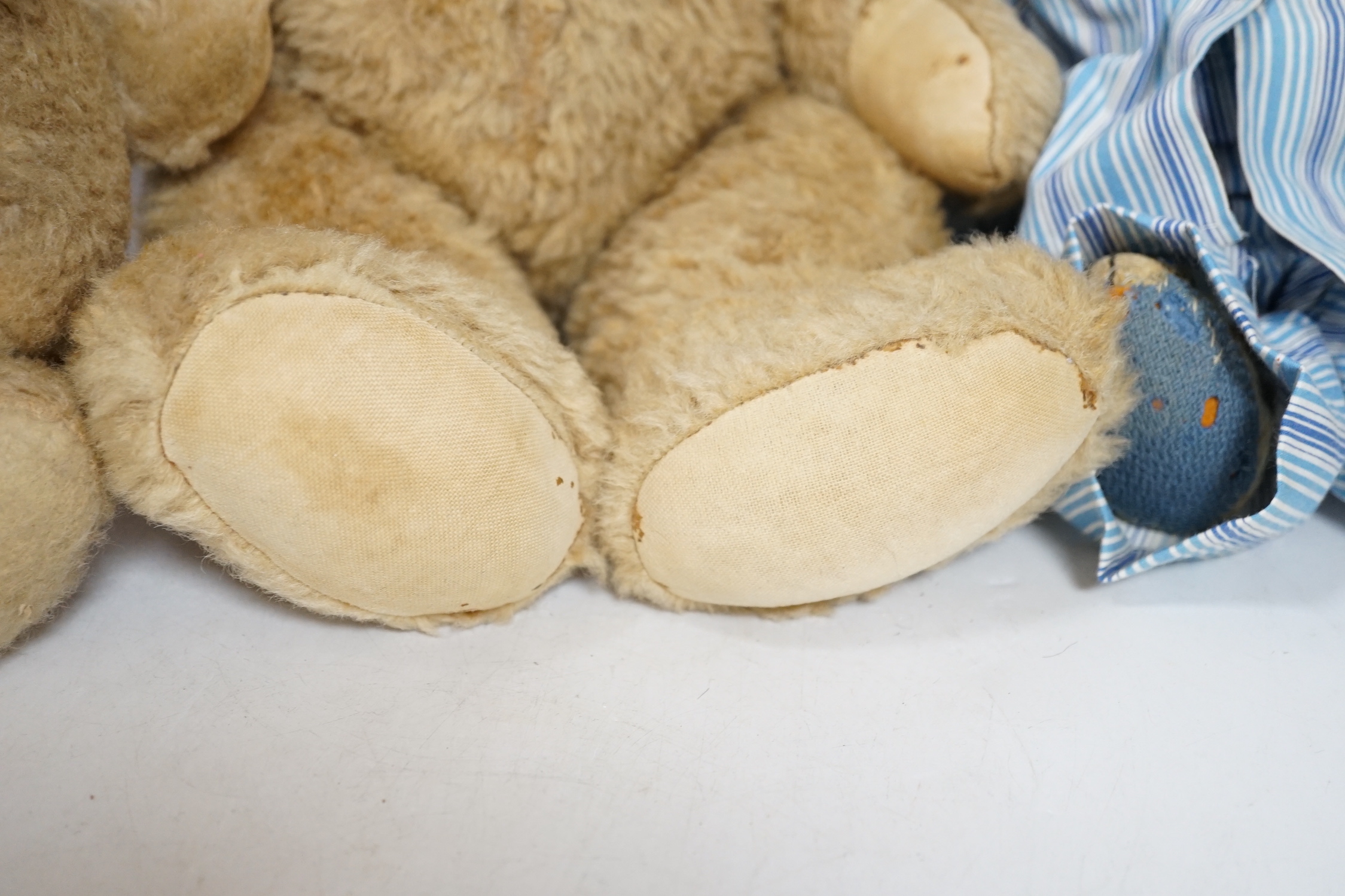 Two Invicta bears, 30cm and 45cm, some wear, and a Merrythought bear, dressed in vintage dressing gown and pyjamas, 32cm high, with hair loss